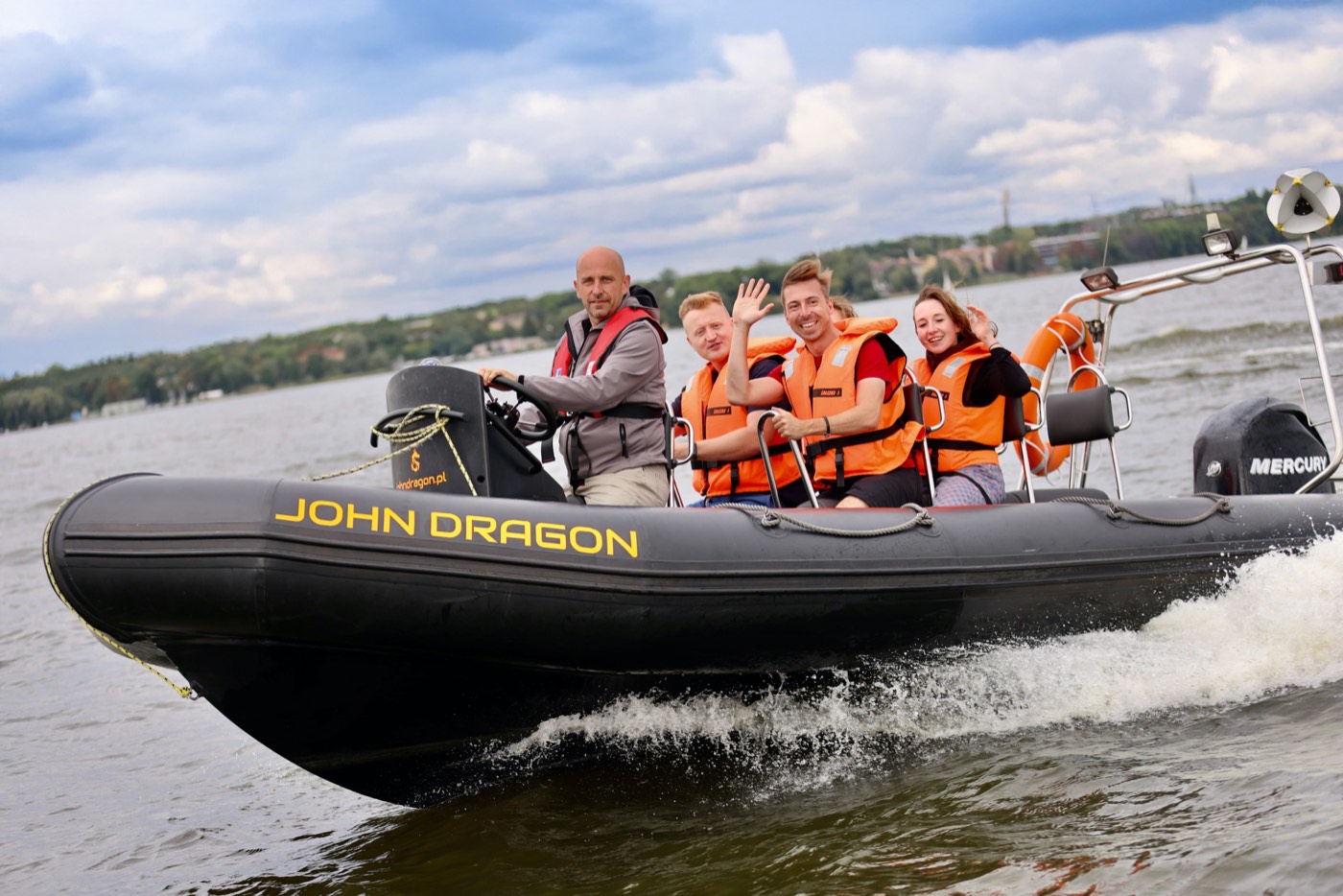 Cała grupa gości machająca na motorówce RIB John Dragon